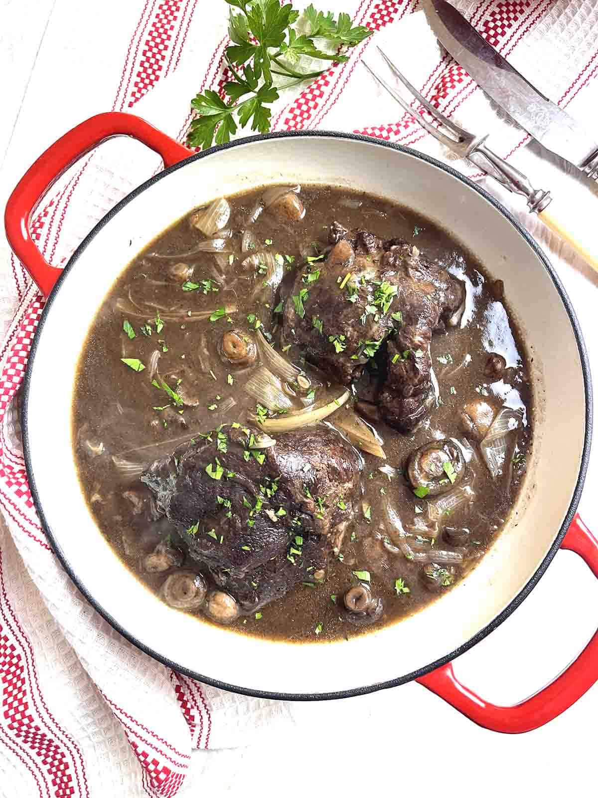 slow cooker beef cheeks in a casserole dish.