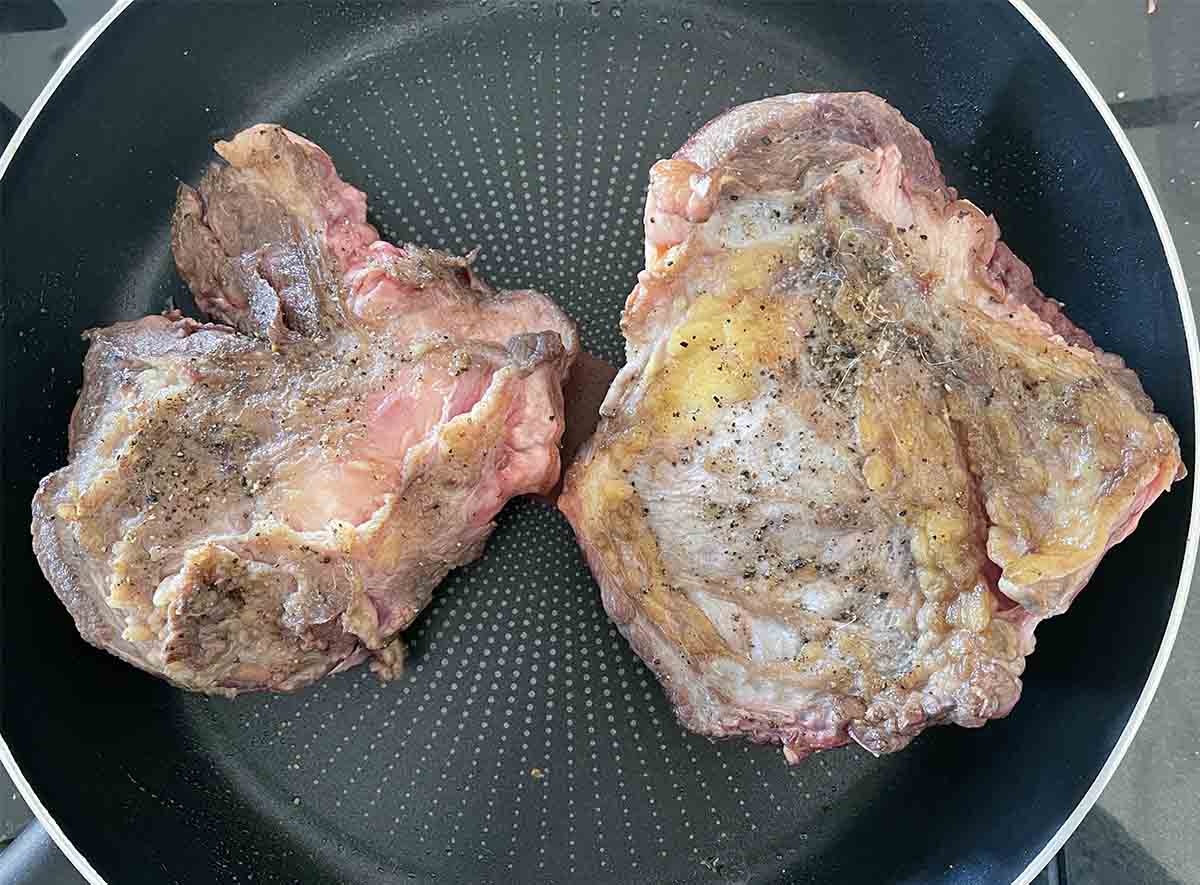 beef searing in a pan.