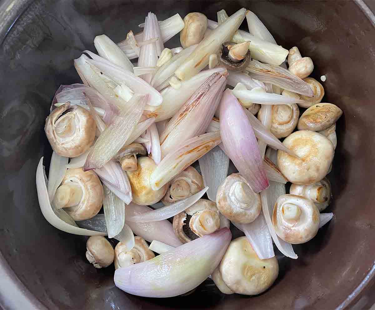 shallots and mushrooms in a slow cooker.