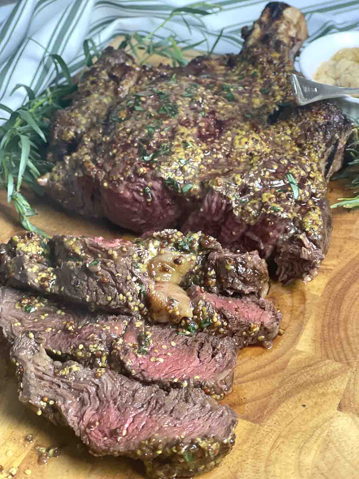 bone in ribeye steak sliced on a board.