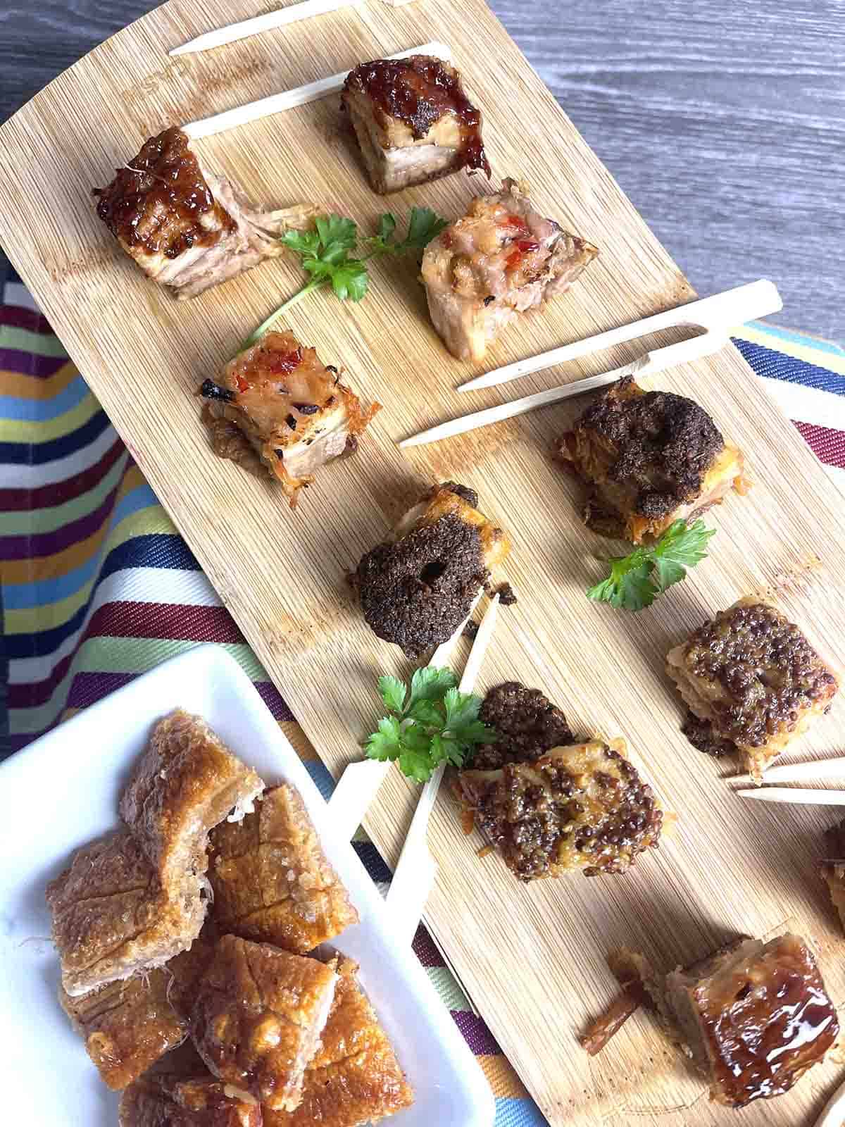 pork belly bites on a board.