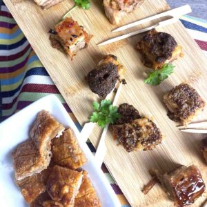 pork belly bites on a board.