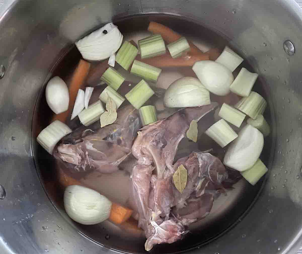 carcasses and vegetables in a stock pot.