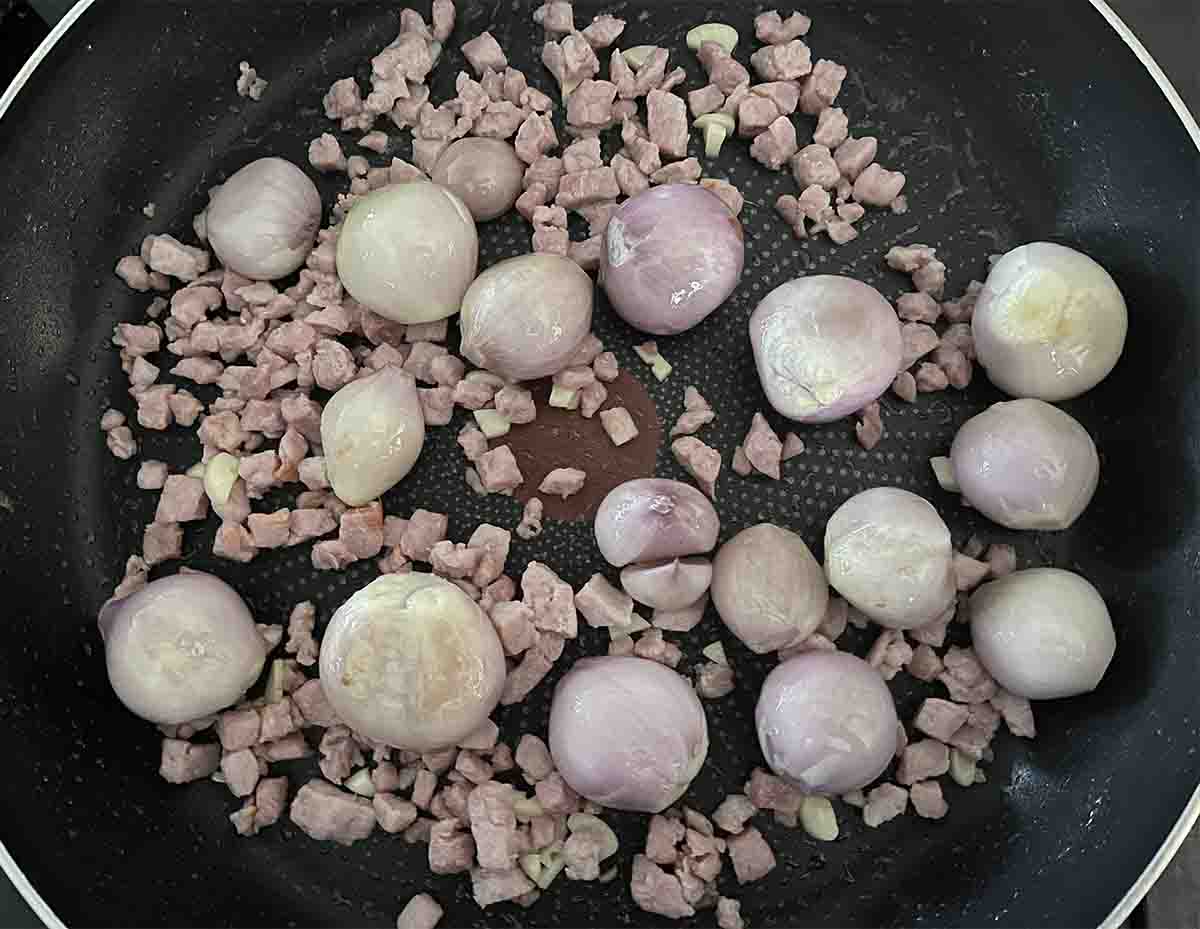 bacon and shallots in a pan.