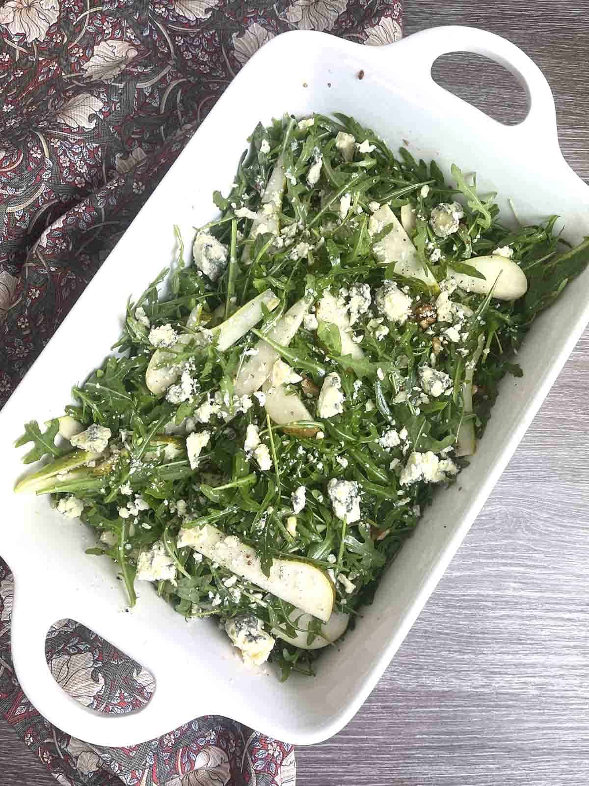 pear and rocket salad in a white dish.