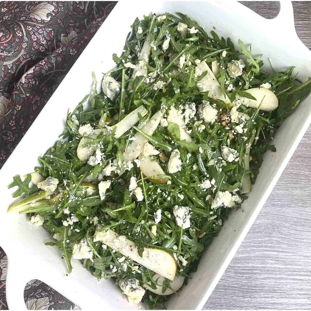 pear and rocket salad in a white dish.