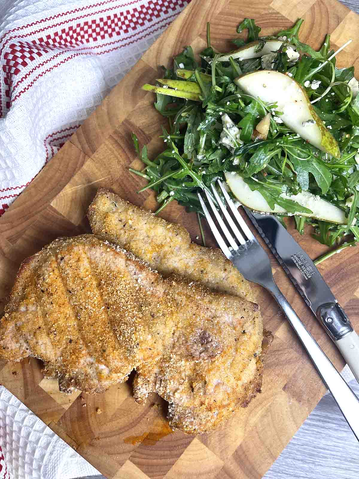 homemade shake and bake pork chops on a board.