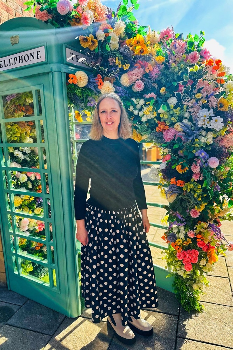 A Telephone Box Full Of Flowers And Styling A Polka Dot Skirt