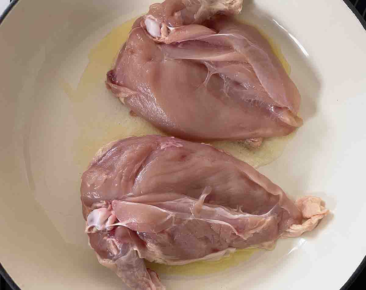 skin side down chicken in a pan.
