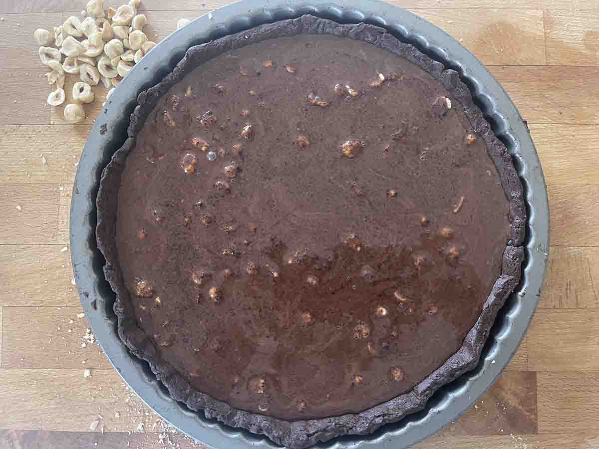 ganache poured overd hazelnuts in the tart shell.