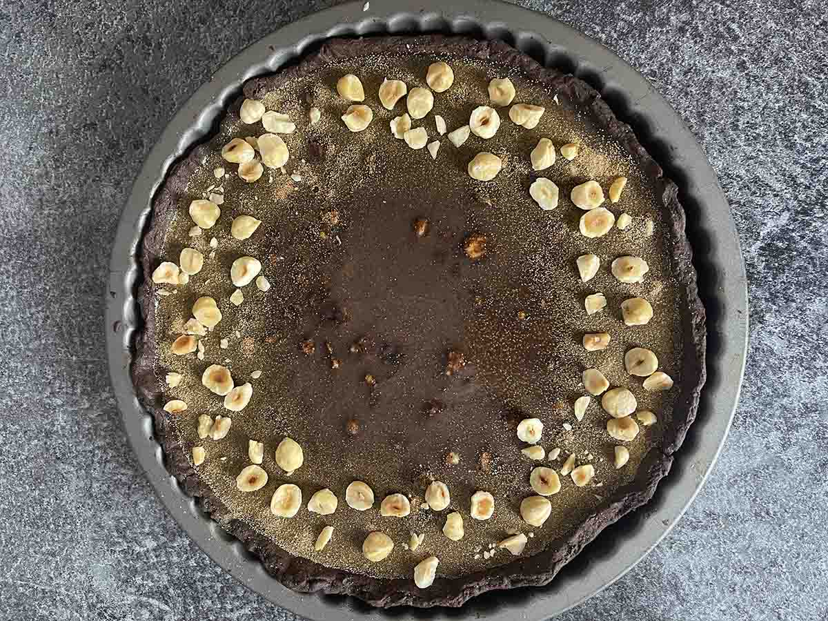 tart decorated with hazelnuts and gold dust.