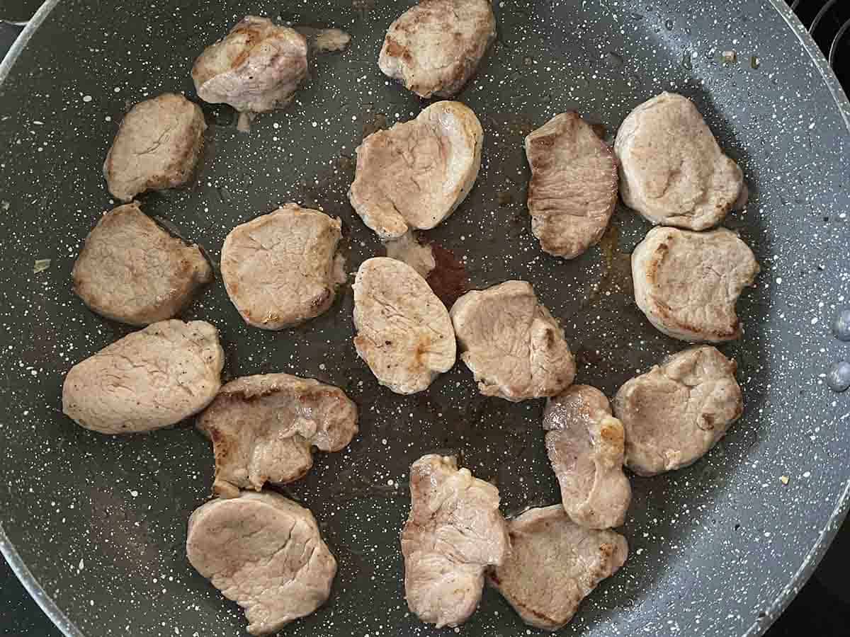 pork fillet cooking in a pan.