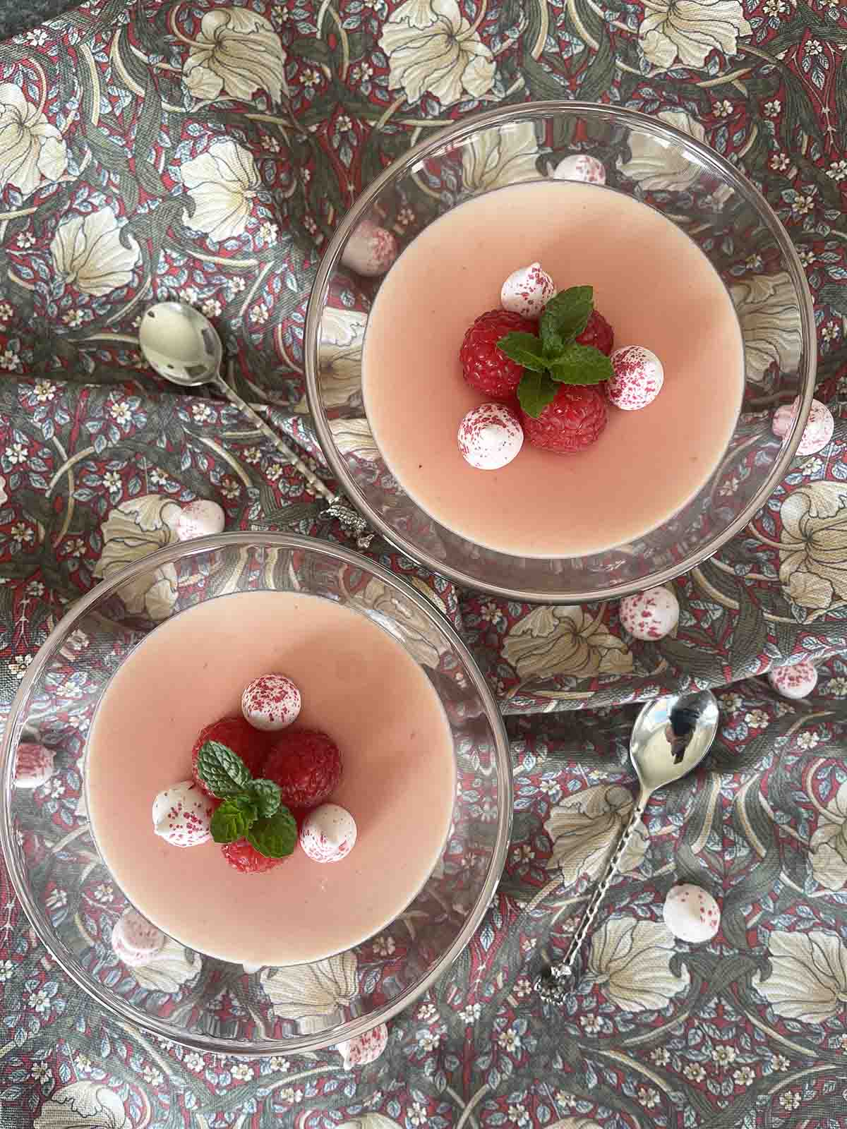 posset decorated with raspberries and mini meringues.